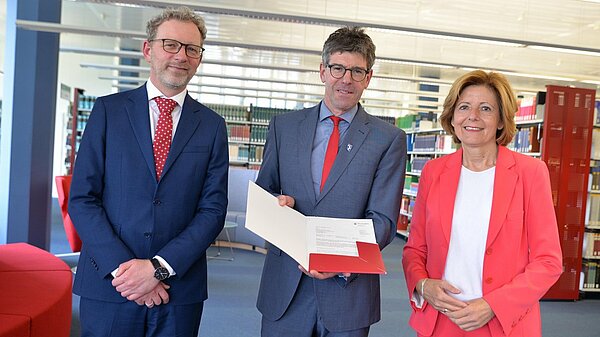 Ministerpräsidentin Malu Dreyer übergab in der Universitätsbibliothek den Förderbescheid an Michael Jäckel (Universitätspräsident) und Andreas Regelsberger (Dekan des Fachbereichs II)